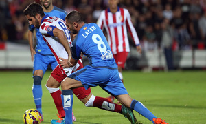 Temporada 14/15. Getafe - Atlético de Madrid. Raúl García se marcha entre dos rivales por velocidad.