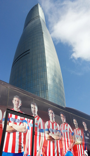 El bus personalizado del Atlético de Madrid delante de una de las torres del fuego