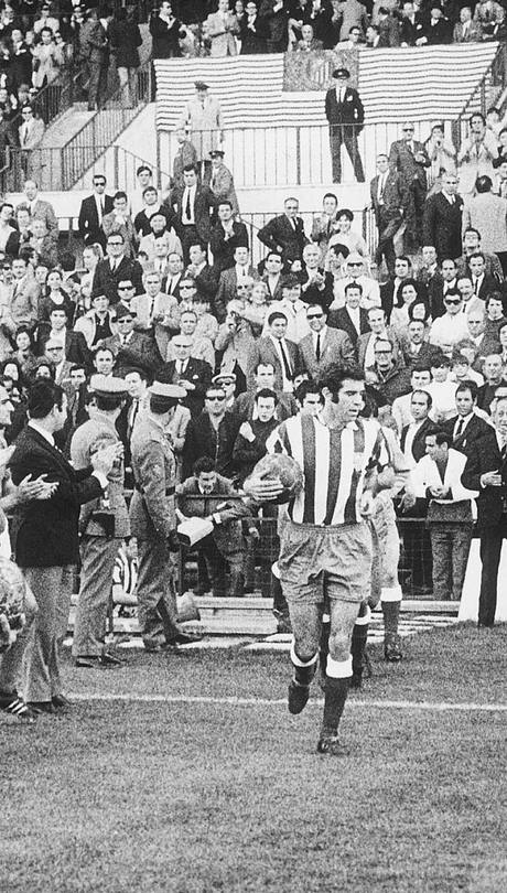 Luis Aragonés, en el centro de la imagen, sale al terreno de juego con sus compañeros ante el pasillo del equipo rival tras quedar campeones